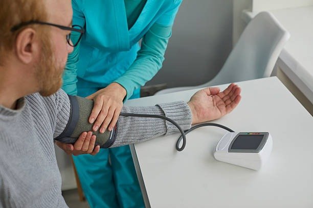 Patient and clinician reviewing a home blood pressure log during a Hypertension visit.